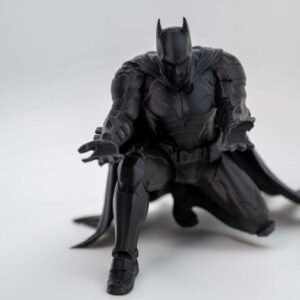 Bat inspired pen holder kneeling caped figure holding a pencil