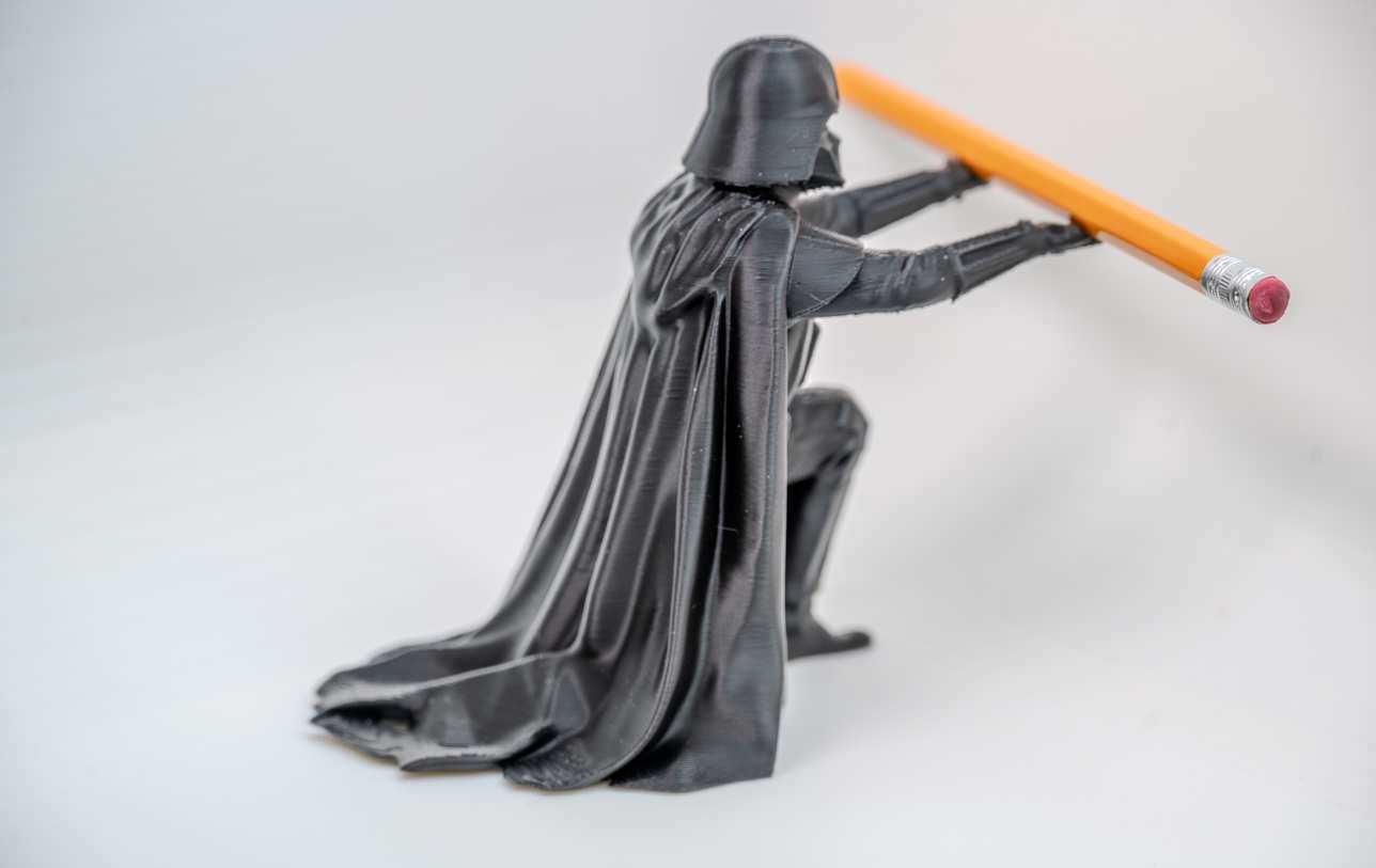 Darth Vader pen holder showing how a standard pencil rests across hands