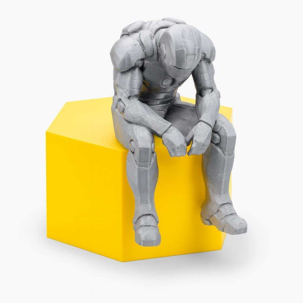 sad superhero desk figurine sitting on a ledge in grey PLA