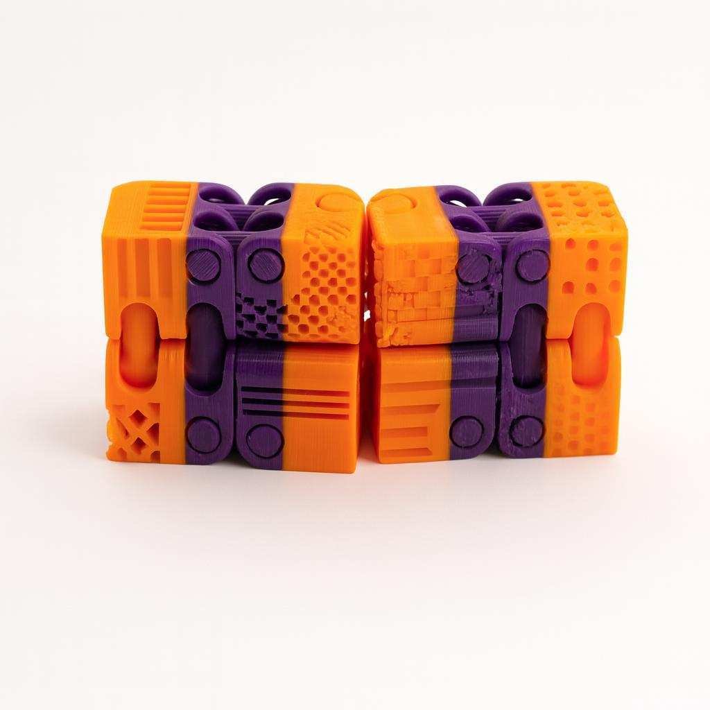 Two connected halves of a 3D printed infinity fidget cube showing textured faces