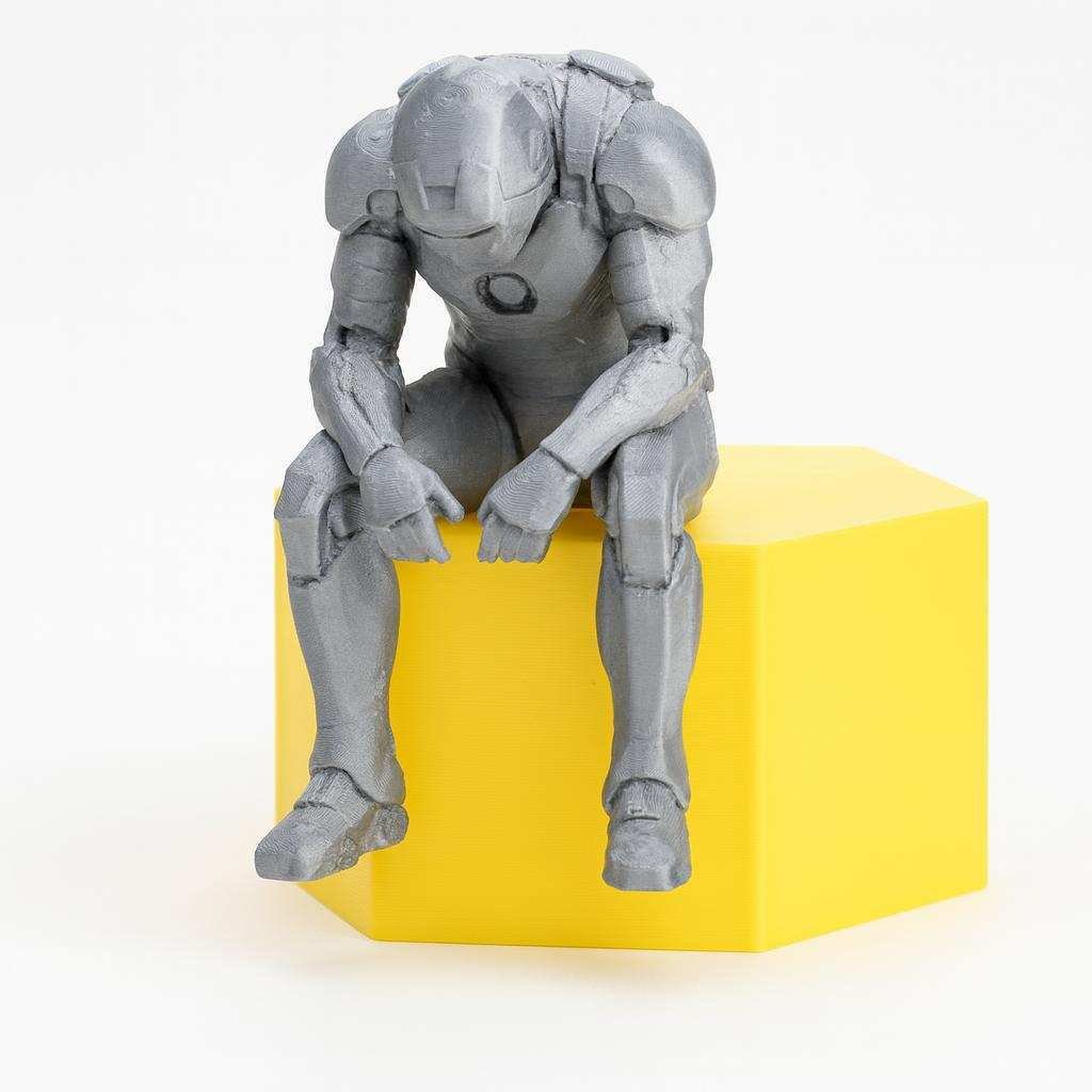Front view of reflective seated superhero-style desk decor figure